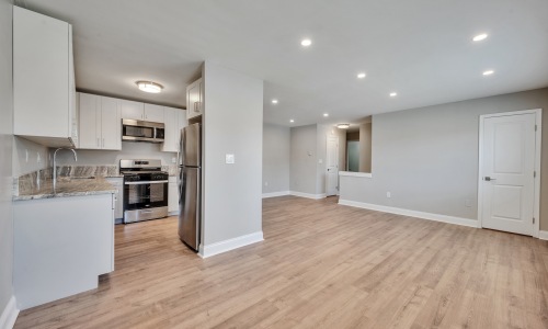 a kitchen and living room with wood floors