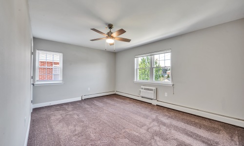 a bedroom with carpet and a fan